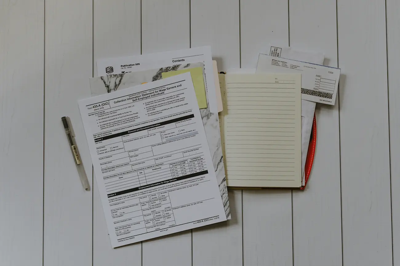 Lease paperwork on a desk with a pen and notebook, symbolizing reviewing lease terms.