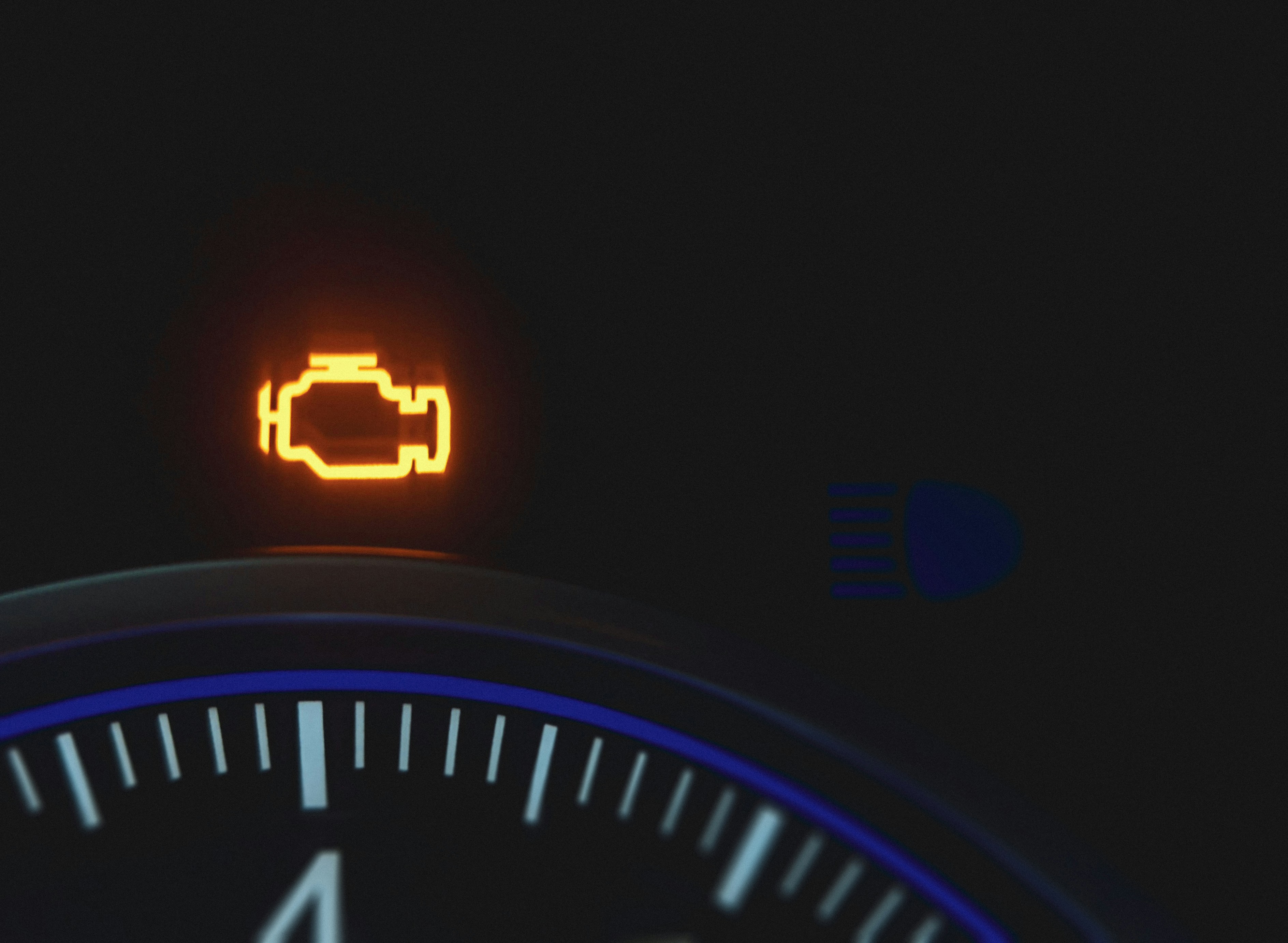 Check engine warning light on a car dashboard.