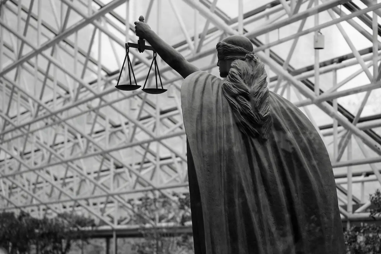 Black-and-white justice statue with scales, symbolizing U.S. commercial lease regulations.