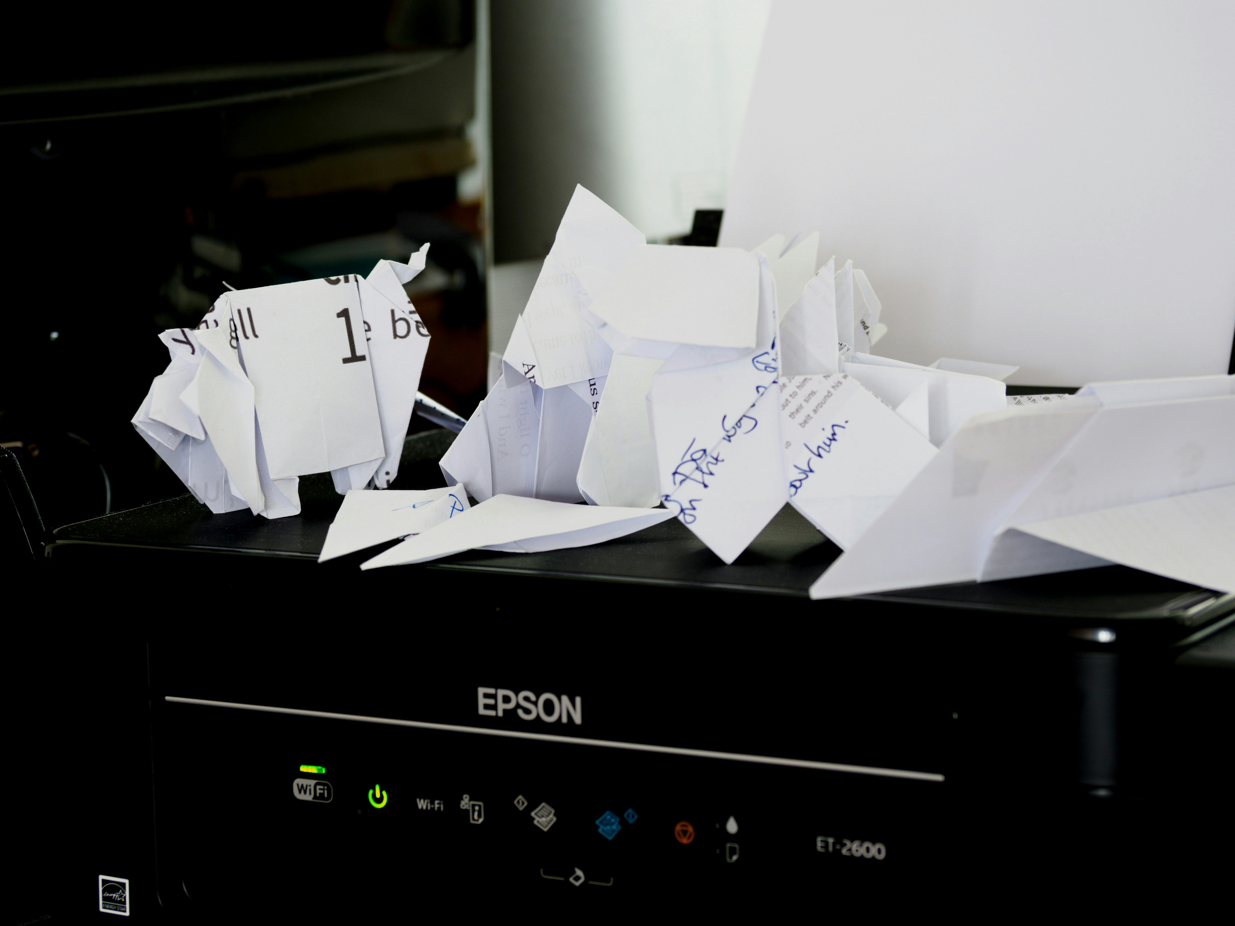 Crumpled paper and scraps piled on top of a printer, suggesting paperwork mistakes