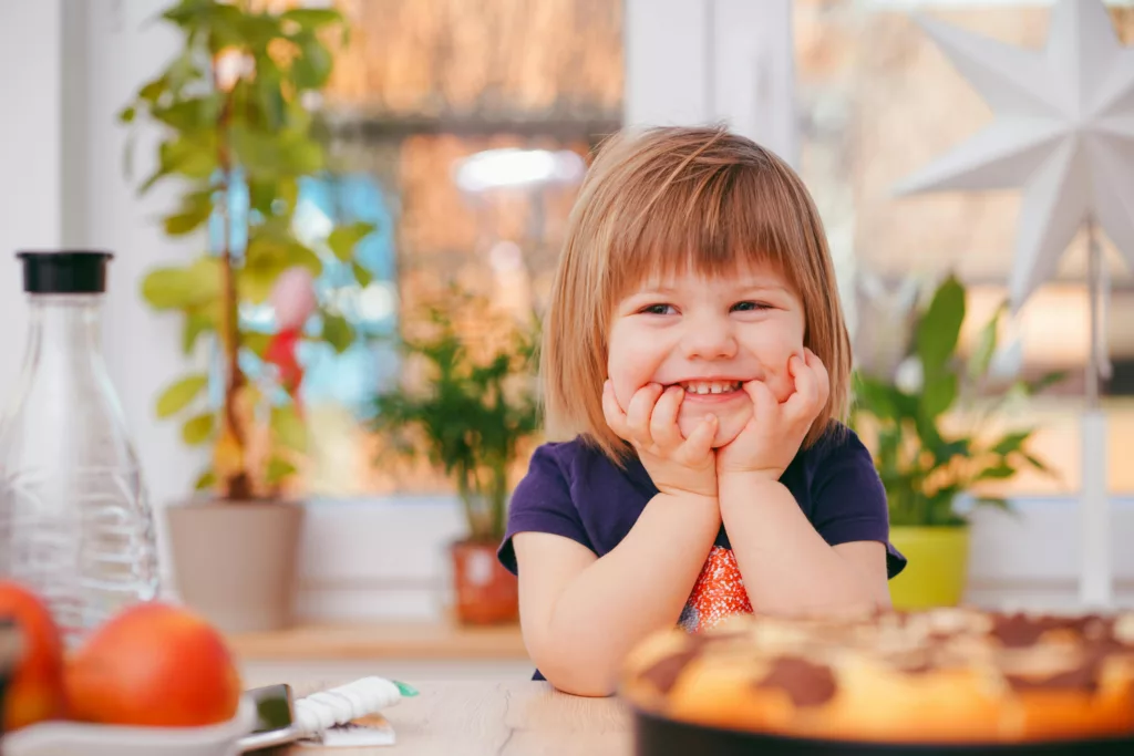 Happy child sitting at a table, symbolizing child custody matters.