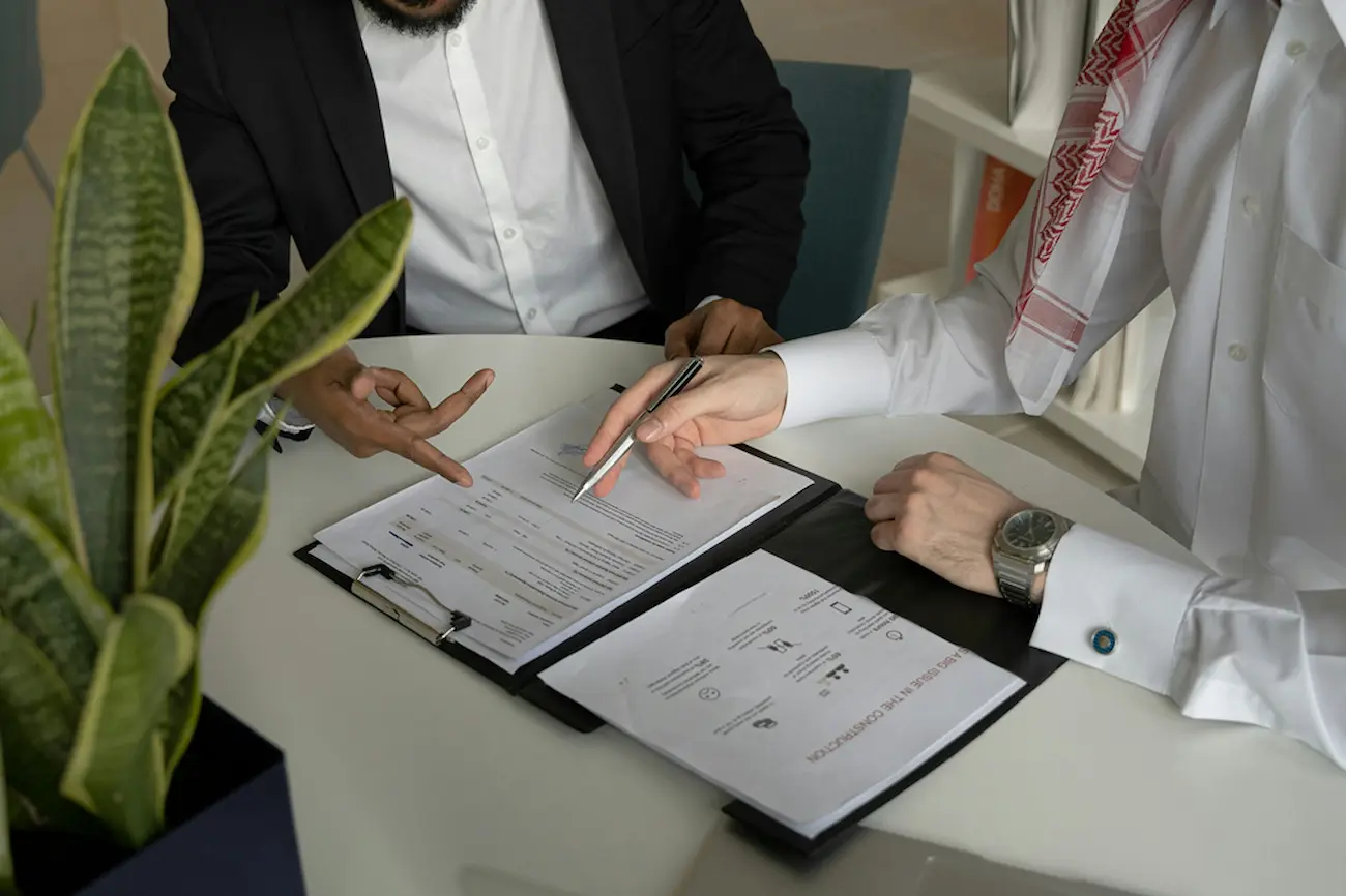 Two people reviewing and signing a personal loan agreement at a table.