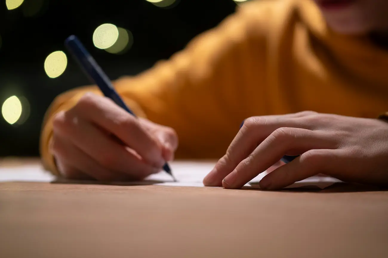 Close-up of hands signing a document, symbolizing completing a lease agreement template.