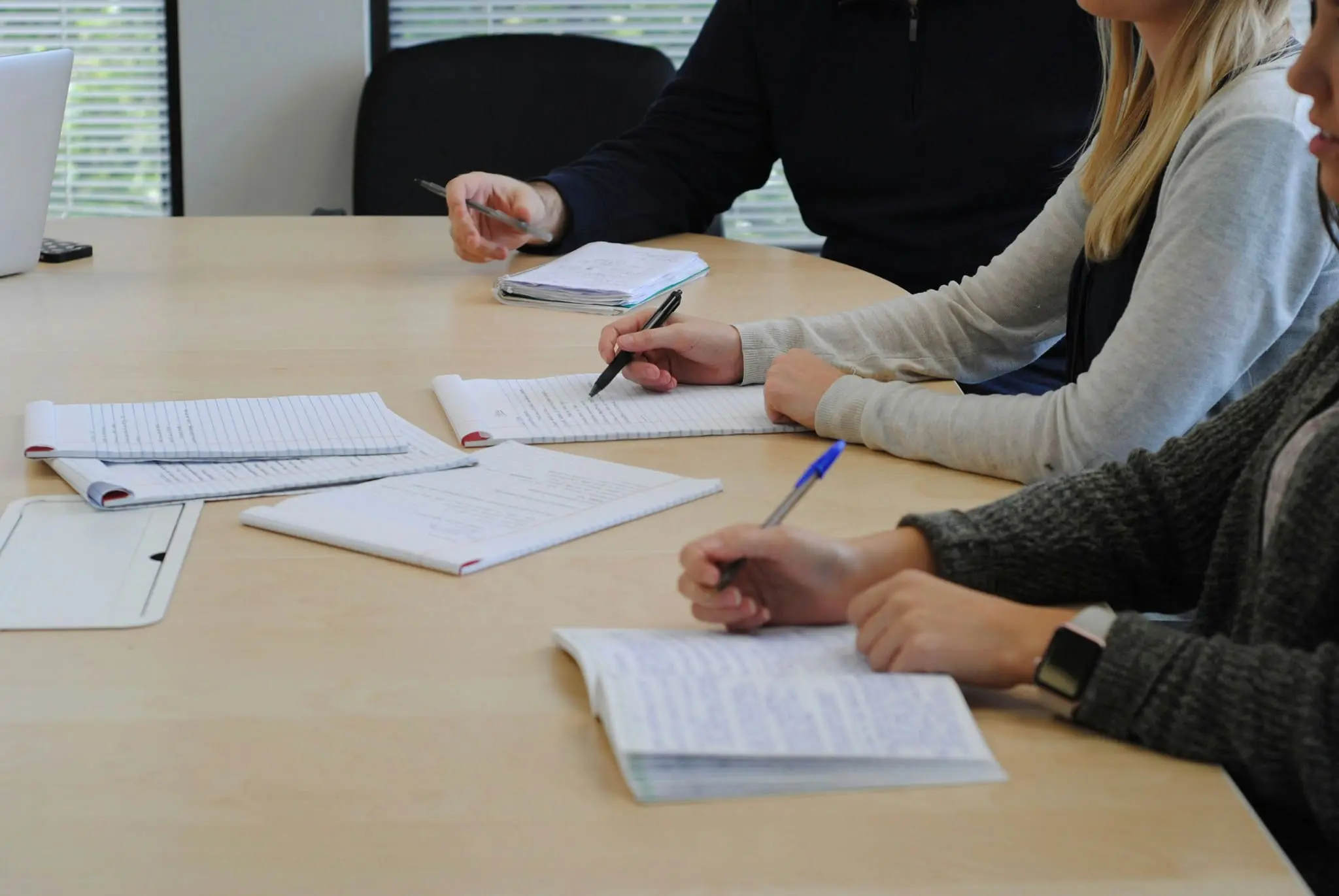 People reviewing notes together, discussing key terms of a letter of intent