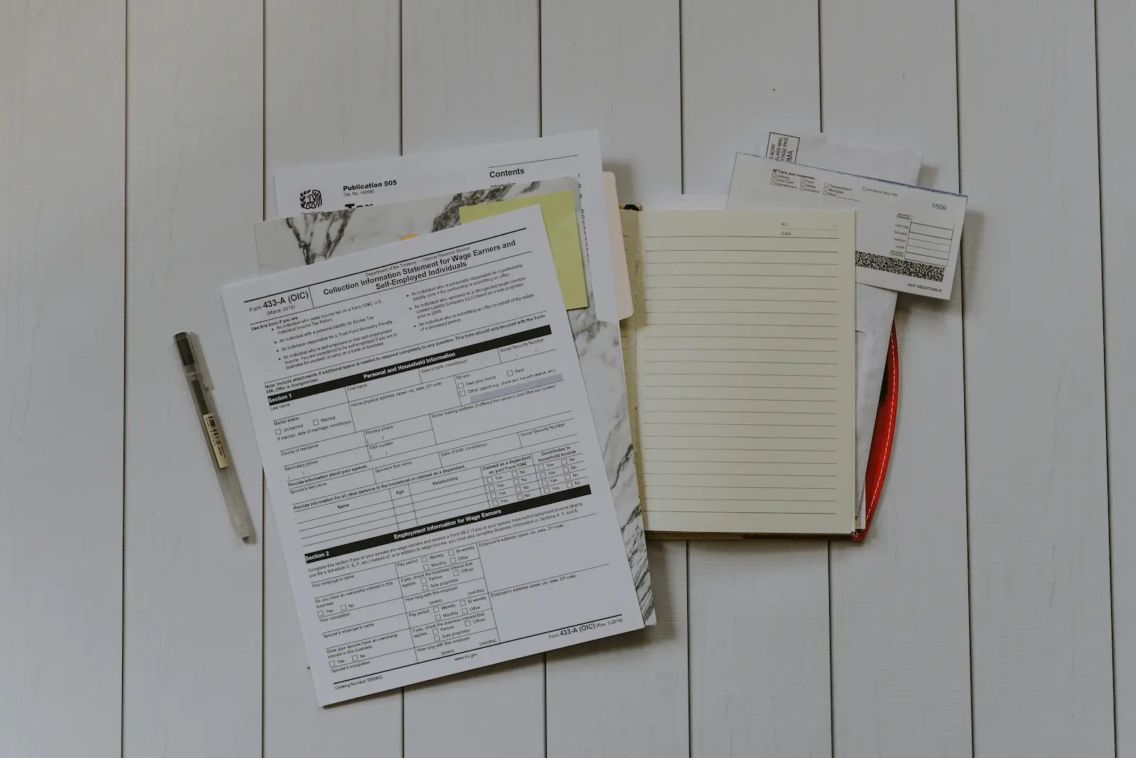 OSHA injury documentation forms and a blank notebook on a desk
