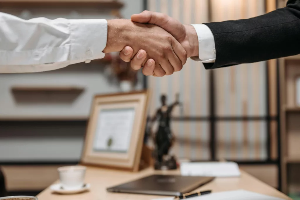 Lawyer and client shaking hands after a legal agreement.